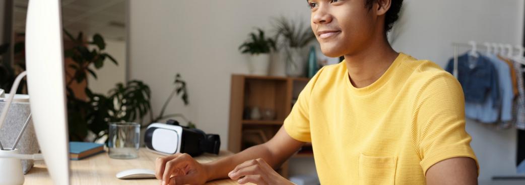 Male learner at computer wearing yellow tshirt.jpg