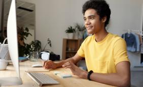 Male learner at computer wearing yellow tshirt.jpg