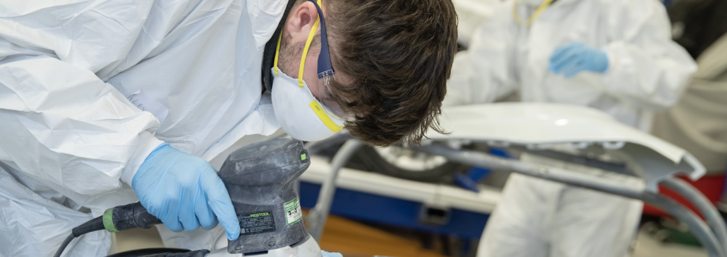 Apprentices working on a car.png